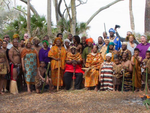 People sitting and standing in various African dress. 