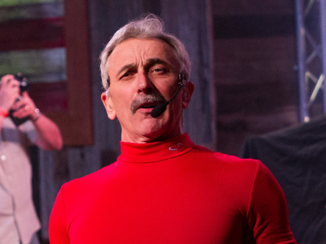 Aaron Tippin in a red turtleneck shirt. 