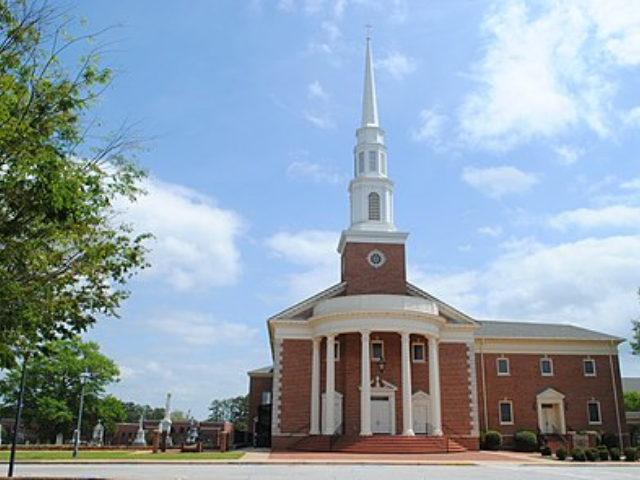 A brown brick and white accented church.