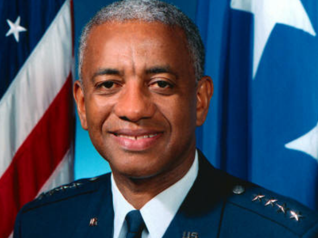 A smiling Lloyd Fig Newton wearing a navy blue dress uniform with his four general stars on his shoulders.