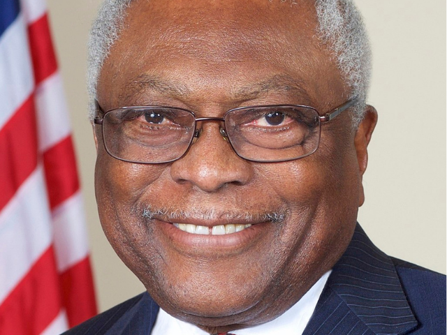 A smiling James Clyburn wearing a dark pinstripe suit. 