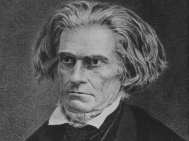 A stern looking John C. Calhoun wearing a dark suit and light color undershirt. 