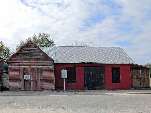 A red wooden building with a metal tin roof. 