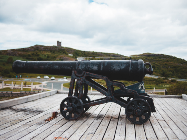 black cannon on brown wooden dock during daytime