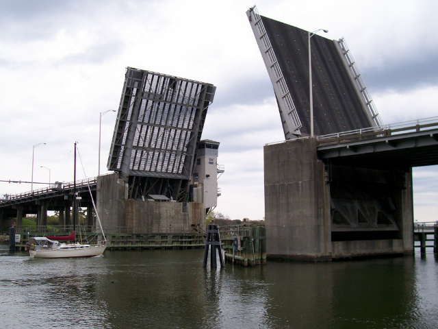 Metal and concrete bridge halves open up to let boat through. 