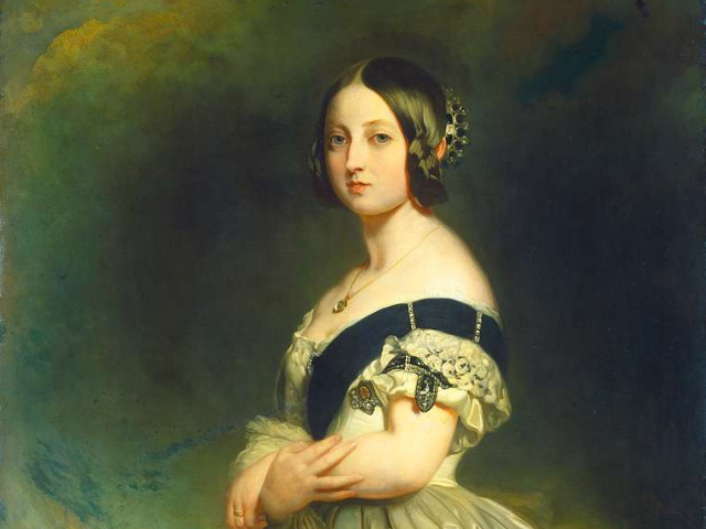 A pale young woman with black hair wearing a off shoulder white dress with a navy blue slash