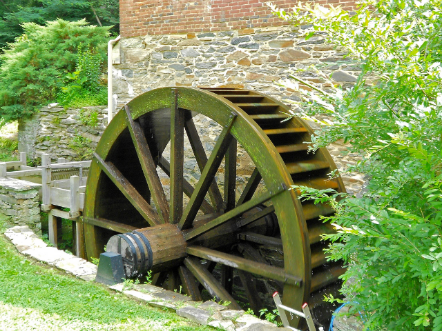 A large brown wooden wheel need to a break building