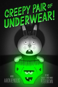 A rabbit holds a pair of glowing green underwear with a Frankenstein face in the center.