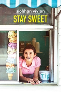 A smiling teen girl hangs out in a drive through window.
