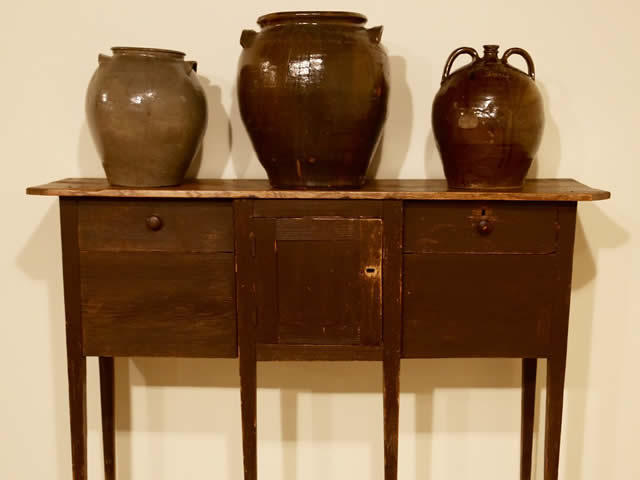 Three David Drake works of pottery on a sideboard.