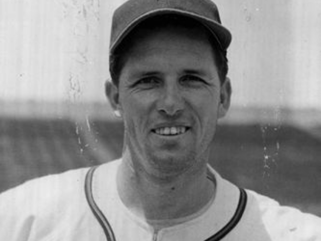 A smiling man in a baseball uniform