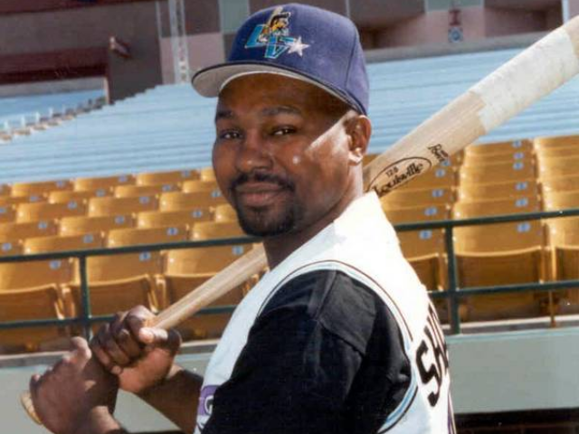 Color photograph of Mike Sharperson holding a bat in his right hand