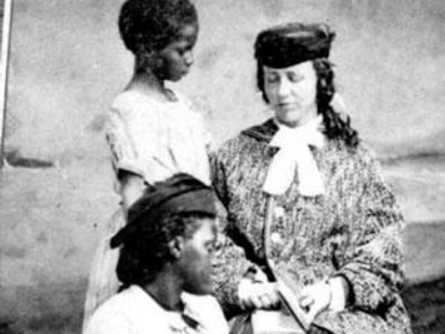 A white woman sitting next to two black girls.