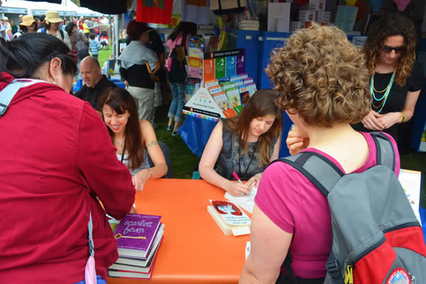 American authors Lauren Myracle and Maureen Johnson signing copies of their work at a book festival in 2012.